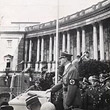 Anschluss Österreichs an das Deutsche Reich 1938. Hitler am Stehpult am Heldenplatz, hinter ihm, tiefer stehend Militärs, zwei Fotografen bei der Arbeit. © VGA (E3/553)